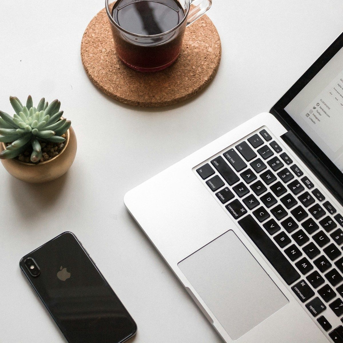 Laptop, phone and coffee on a desk